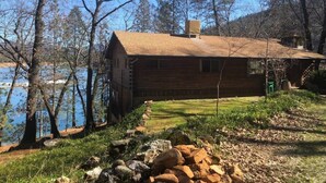 A log cabin by a lake with a clear view of the water, surrounded by trees. - Lakefront #1 Cabin on Acre, Kayaks, Paddle Boards  - Shasta Lakeshore Retreat #4 (Lakehead)