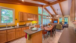A spacious kitchen with wooden cabinets, a central island, and large windows. - On the Chattahoochee River-Walk to Downtown Alpine Helen (Helen)