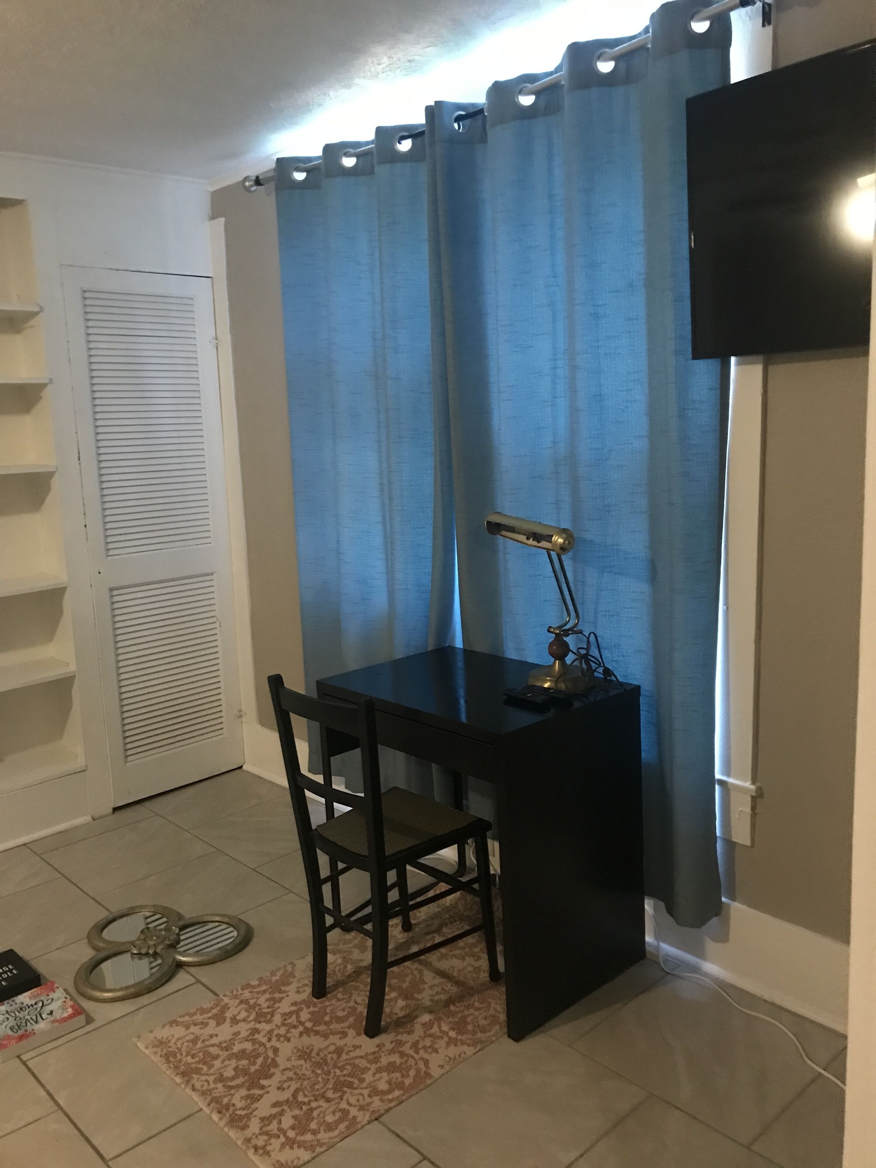 Un petit bureau privé, équipé d’un bureau, d’une chaise et d’un téléviseur fixé au mur.
