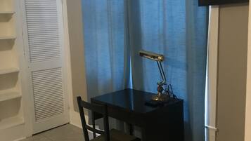 Un petit bureau privé, équipé d’un bureau, d’une chaise et d’un téléviseur fixé au mur.