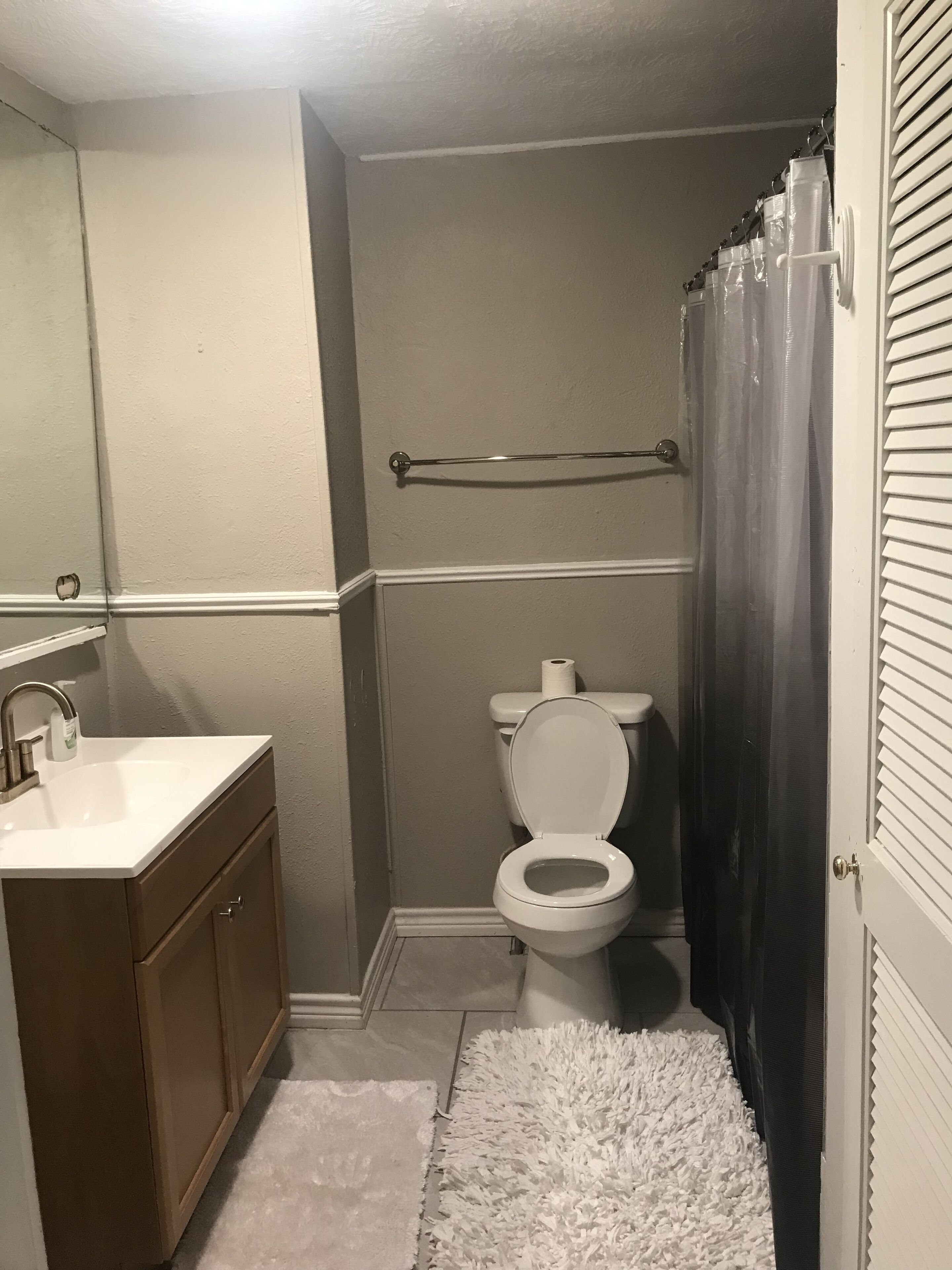 Un baño con inodoro, lavamanos y espejo.