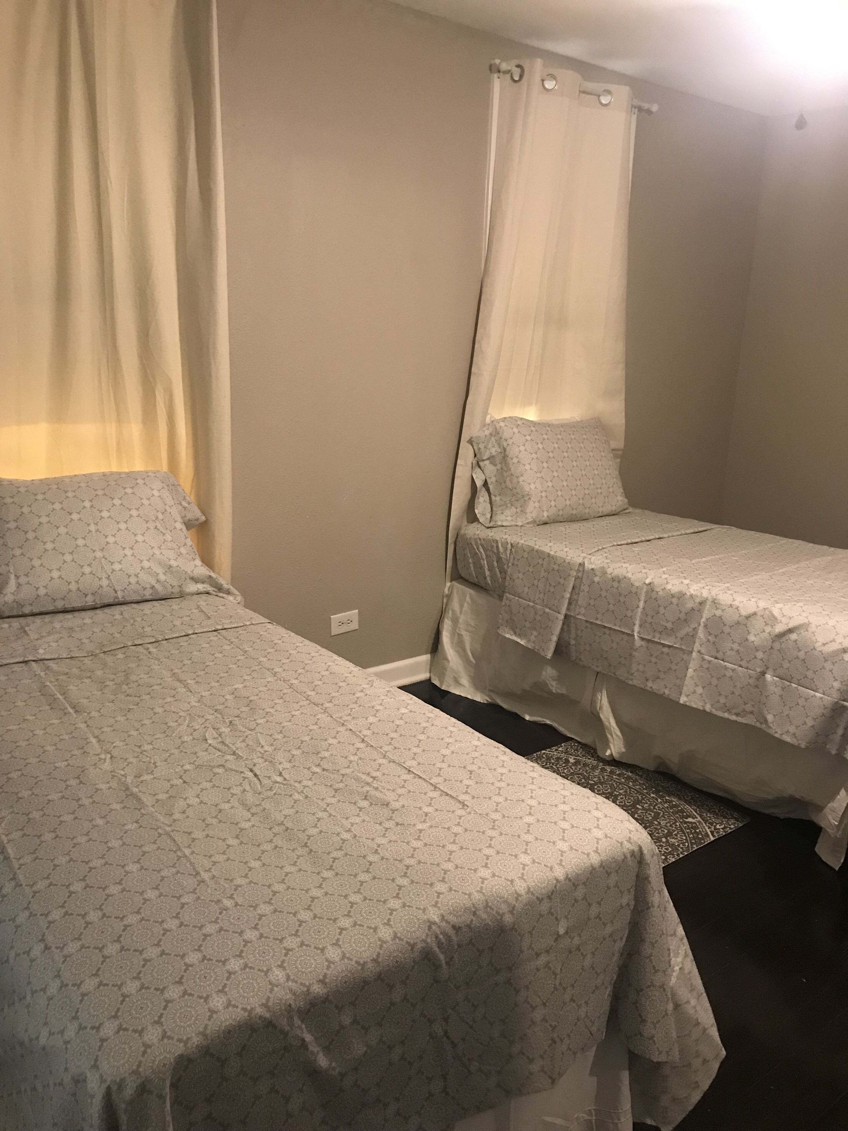 A bedroom with two beds, each covered with patterned bedding.