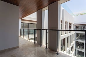 A modern interior with a glass railing, large windows, and a high ceiling.
