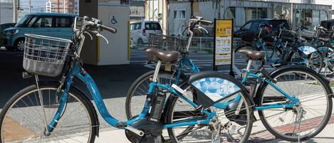 Varias bicicletas estacionadas en un área designada con un letrero que indica que es solo para huéspedes del hotel.