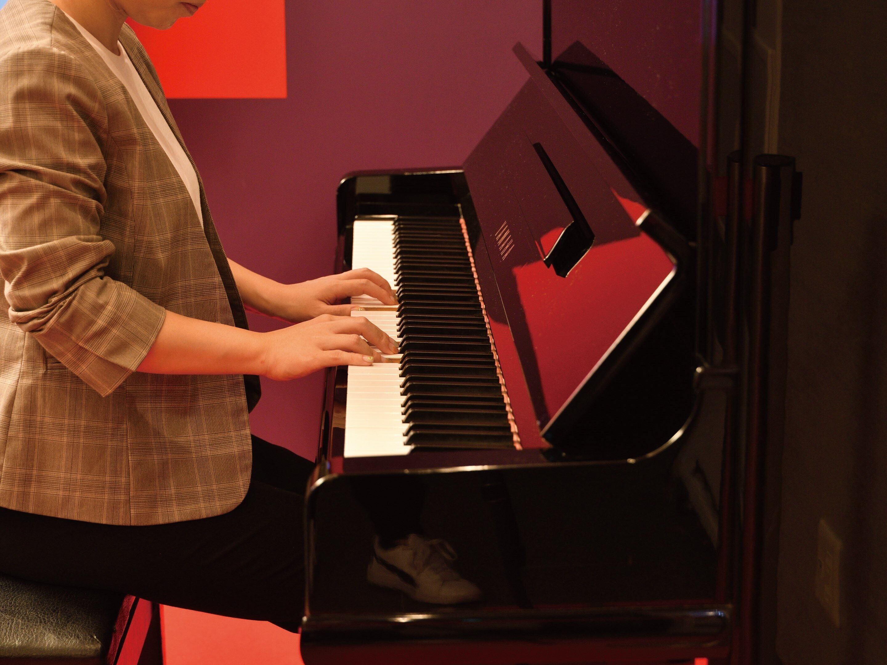 A person playing a black piano.