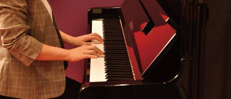 A person playing a black piano.