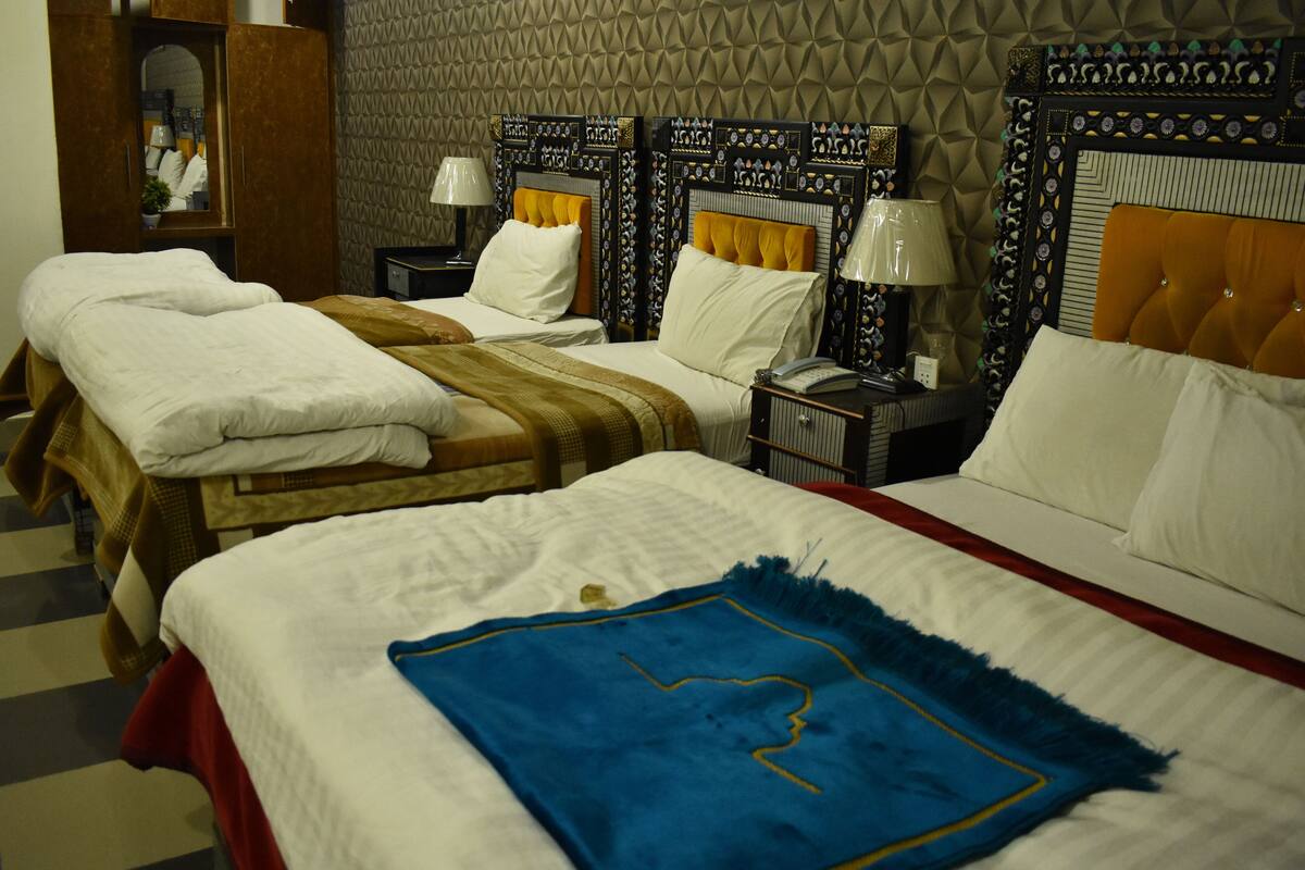 A hotel room with two beds, a wardrobe, and a mirror.