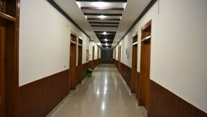 A long, narrow hallway with wooden paneling on the walls and a tiled floor. - Rose Valley Hotel (Balakot)