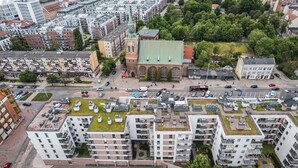 Luchtbeeld van een stad met moderne gebouwen, een opvallende kerk en een parkeerplaats.