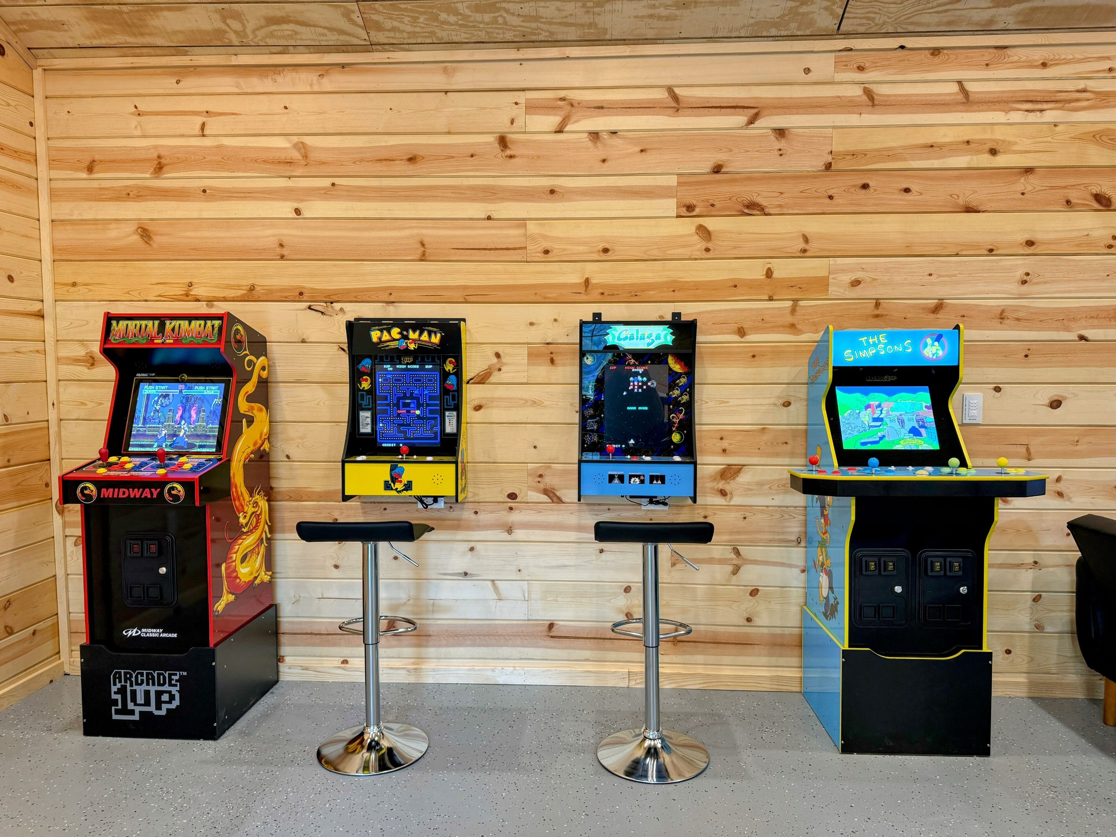Four arcade machines against a wooden wall.