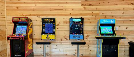 Four arcade machines against a wooden wall.