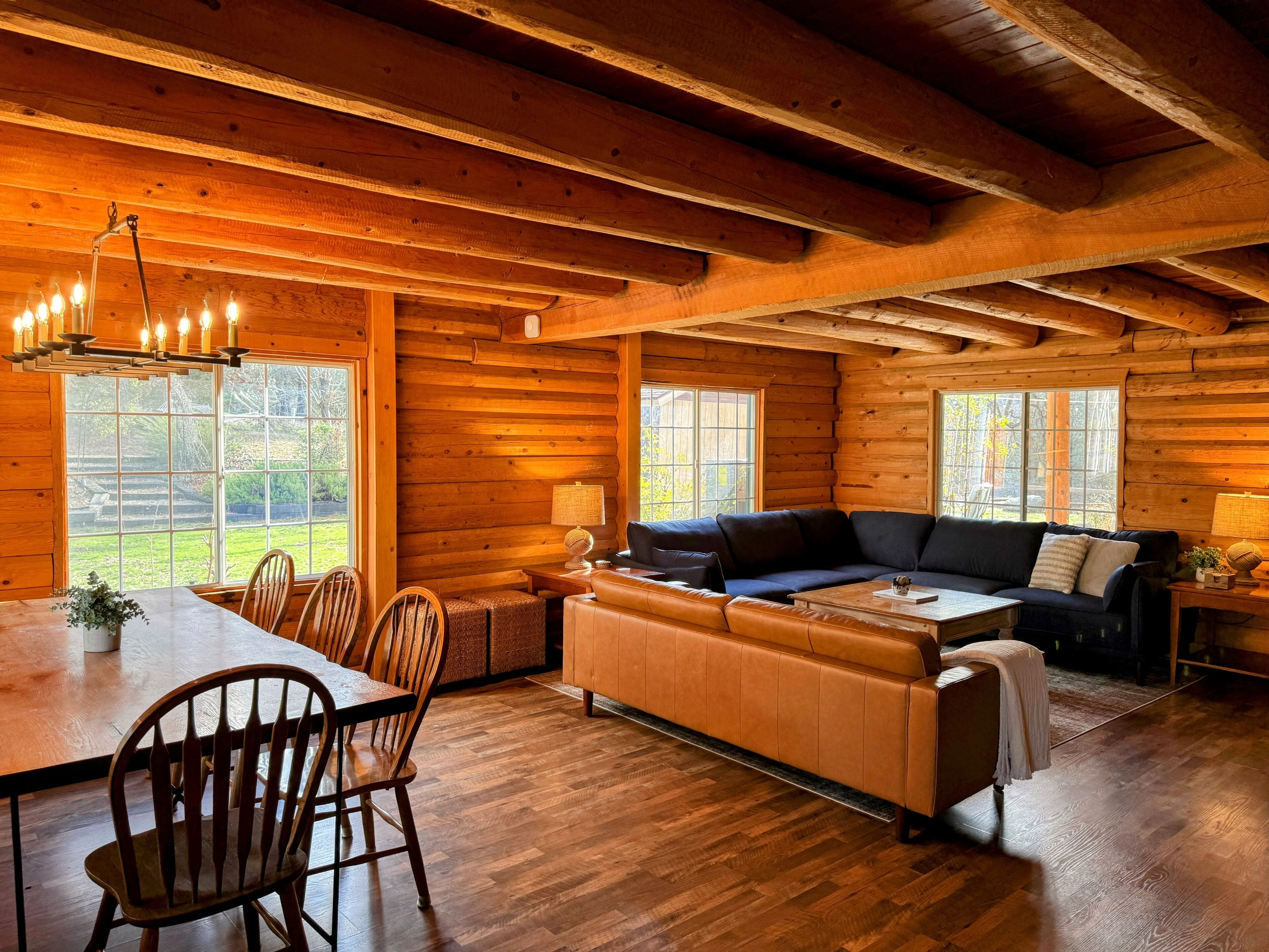 L’intérieur d’une cabane en rondins comprend un coin repas, un canapé et une cheminée.