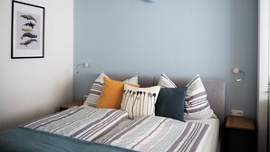 A bedroom with a bed, pillows, a wall-mounted light, and a framed picture of dolphins. - Anastacia Premium Apartment (Graz)
