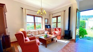A living room with a sofa, armchairs, a coffee table, and a fireplace. - The Cliffs - The Area Nightfall (Viveiro)