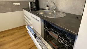 A compact kitchen with a built-in dishwasher, a coffee maker, and a sink. - Beautiful three room apartment. Bright, stylish, cozy (Sachsen - Borna)