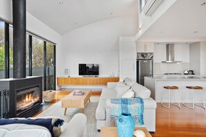 A modern living room with a fireplace, a television, and a sofa. - St Johns Wood Treehouse (Blairgowrie)