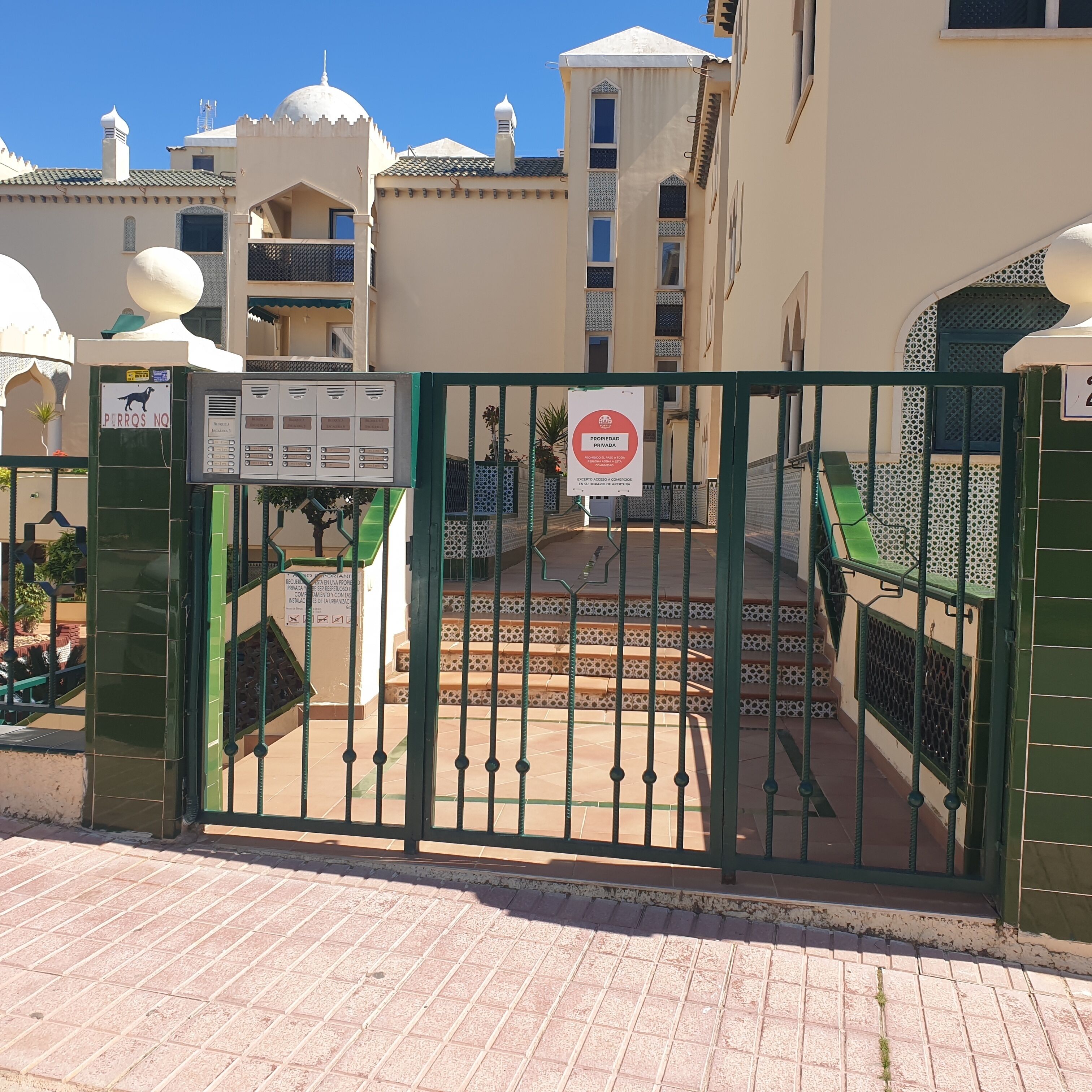 Una entrada cerrada a un edificio con un cartel que indica propiedad privada y un parque canino.