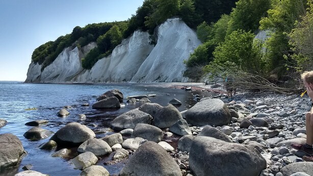 A rocky beach with large boulders and a cliff with white cliffs in the background. - Centrally located, quiet apartment with terrace and garden (Teschenhagen Sehlen)
