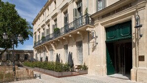 A historic building with a green door, a balcony with wrought iron railings, and a cobblestone courtyard. - Hôtel Richer De Belleval - Relais & Châteaux (Montpellier)