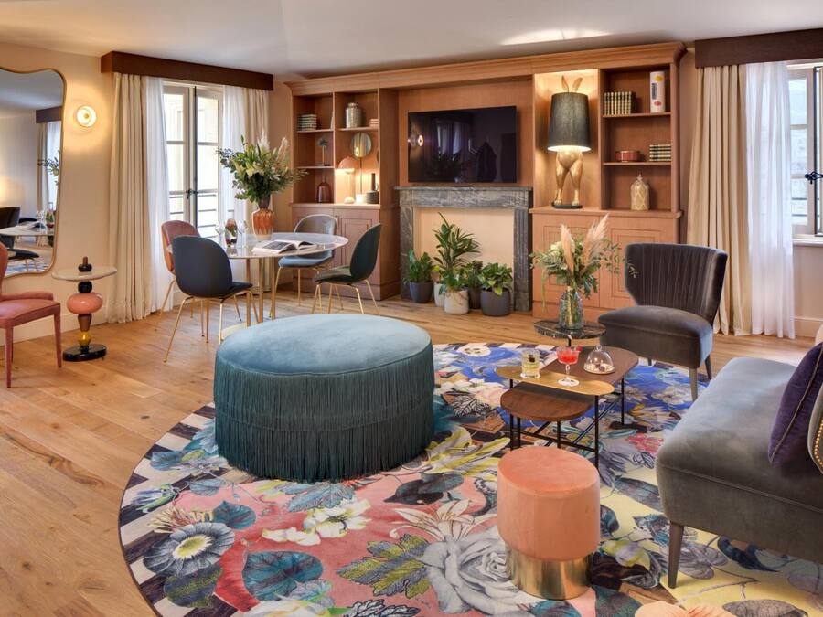 A modern living room with a round coffee table, comfortable seating, a fireplace, and a television.