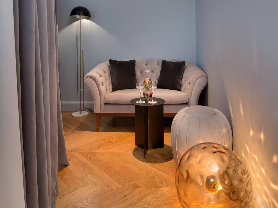 Un salon moderne avec un canapé, une table basse ronde et un lampadaire.