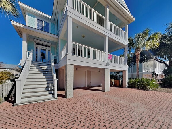A two-story house with a balcony, a front porch, and a driveway.