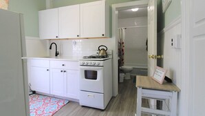 A compact kitchen with white cabinets, a stove, and a small countertop. - Cozy Studio 2 Blocks to Beach & Main Ave | Full Kitchen | Near Asbury Boardwalk (Ocean Grove)