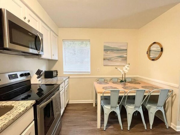 Een microgolfoven, een broodrooster, kookgerei, borden en bestek