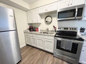 Een microgolfoven, een broodrooster, kookgerei, borden en bestek