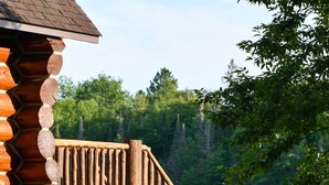 A wooden staircase leading to a cabin with a log exterior, surrounded by greenery and a body of water. - DIRECT ACCESS TO TRAILS 5 and 8, SLEEPS 12, plus PRIVATE LAKE AND TRAILS (Champion)