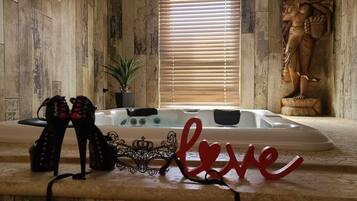 A spa area with a hot tub, a statue, and a decorative 'love' sign.