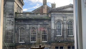 A view of a historic building with large windows and a small boat model in the foreground. - Rose Apartment 2-bed Apt Town Centre Ayr (Ayr)
