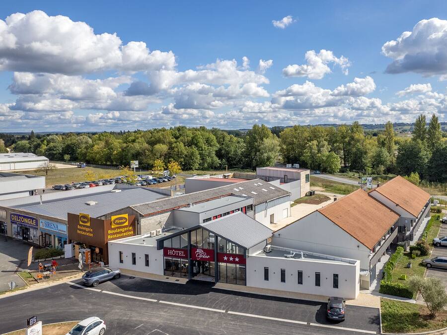 Ein Hotel mit modernem Design, das eine Glasfassade und eine rote Beschilderung zeigt.