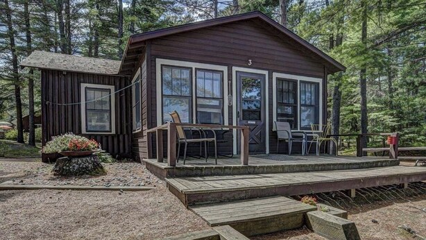 Une cabane dotée d’une terrasse, d’un petit porche et d’un espace jardin.