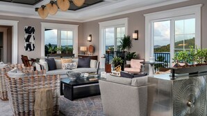 Un salon spacieux avec un plafond haut, de grandes fenêtres et un balcon offrant une vue imprenable.