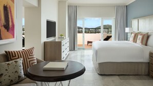 Une chambre d’hôtel comprenant un lit, un bureau avec une télévision, une table à manger et un balcon avec vue.