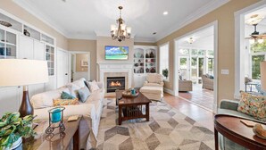 A spacious living room with a fireplace, comfortable seating, and a view to the outside. - Relaxing Waterfront w/ Dock, Easy Drive, On the Lake (Eatonton)