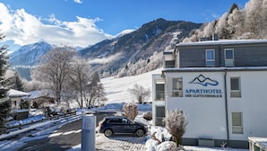 En lejlighedsbygning med udsigt til et bjerg, med teksten "APARTHOTEL DER GLETSCHERBLICK".