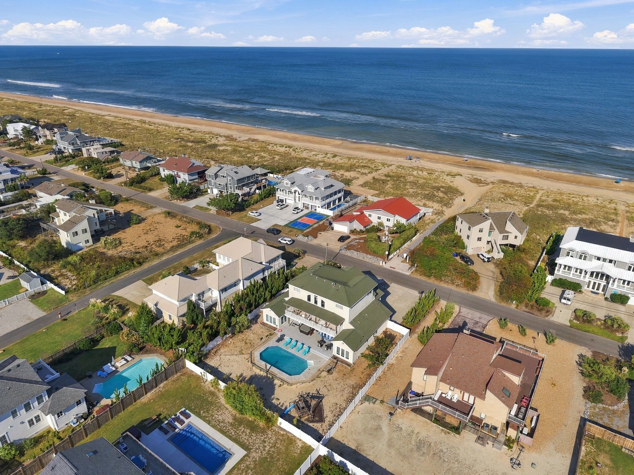 Una zona residencial costera con casas, una playa y una vista despejada del océano.