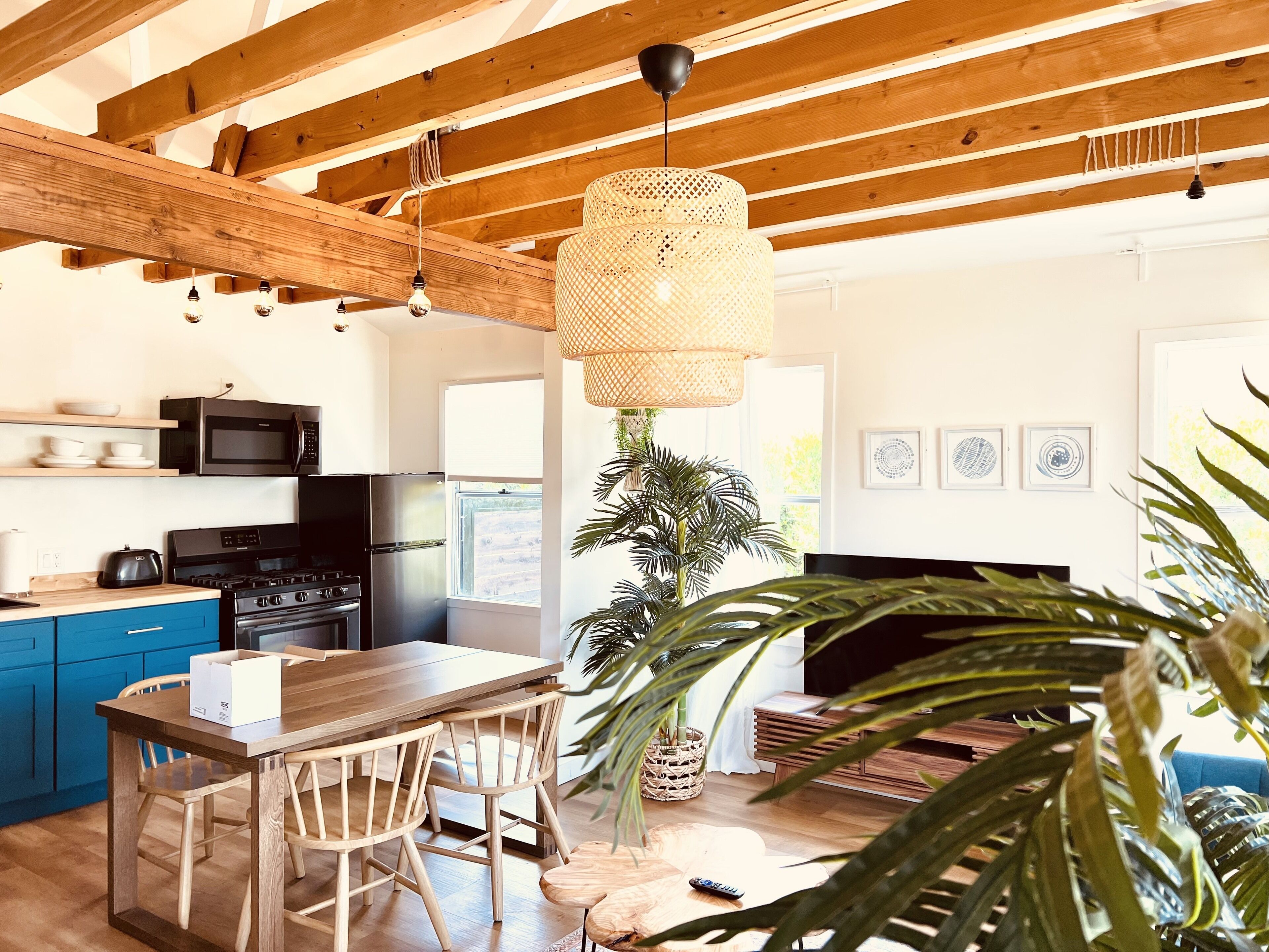 Una cocina moderna con vigas de madera, un comedor y un ventanal grande.