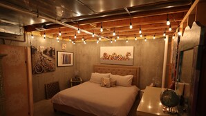 Une chambre à coucher avec un grand lit, une table de chevet, une commode et un globe terrestre fixé au mur.