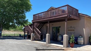A two-story building with a balcony and a staircase leading to the upper level. - Cabernet Cottage (Cottonwood)