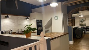 Et moderne køkken med en marmorbeklædt bagvæg, en træø med en kogeø og en potteplante.