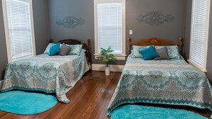 A bedroom with two beds, a potted plant, and decorative wall art. - Spacious Country Living Located In The Heart Of Brenham (Brenham)