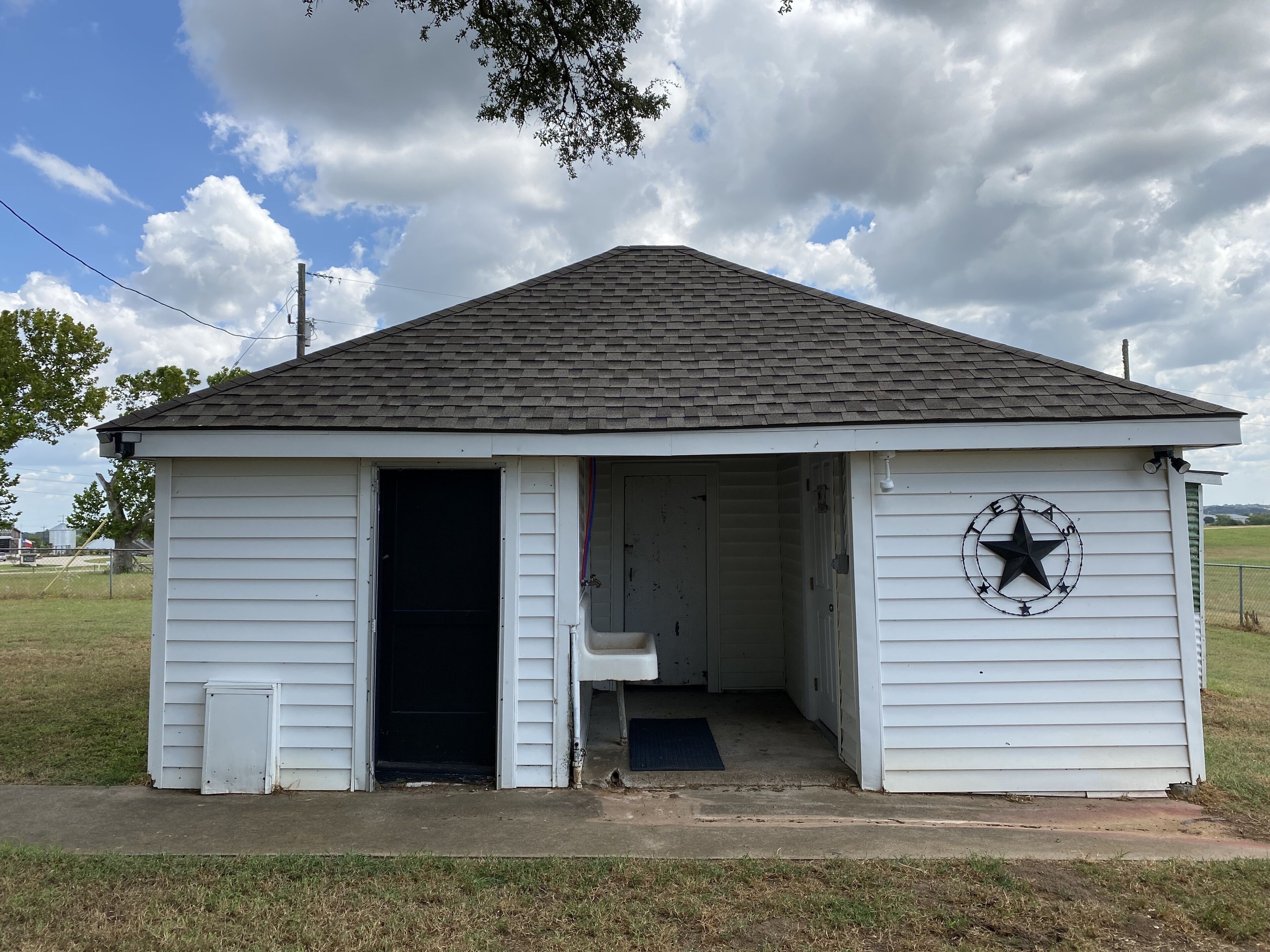 A small white building with a black star and the word "Texas" on the side.