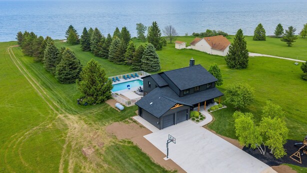 Une propriété résidentielle dotée d’un grand garage, d’une piscine et offrant une vue sur la mer.