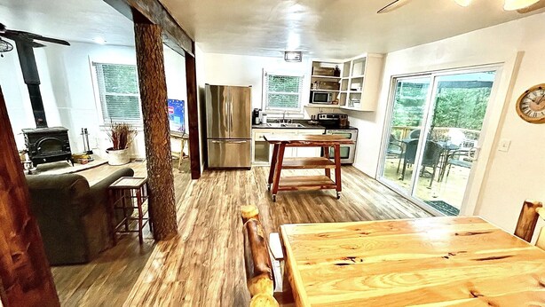 A modern kitchen with a central island, a built-in stove, and a dining area with a wooden table and chairs.