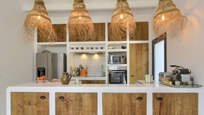 Una cocina con armarios de madera, microondas y cafetera.