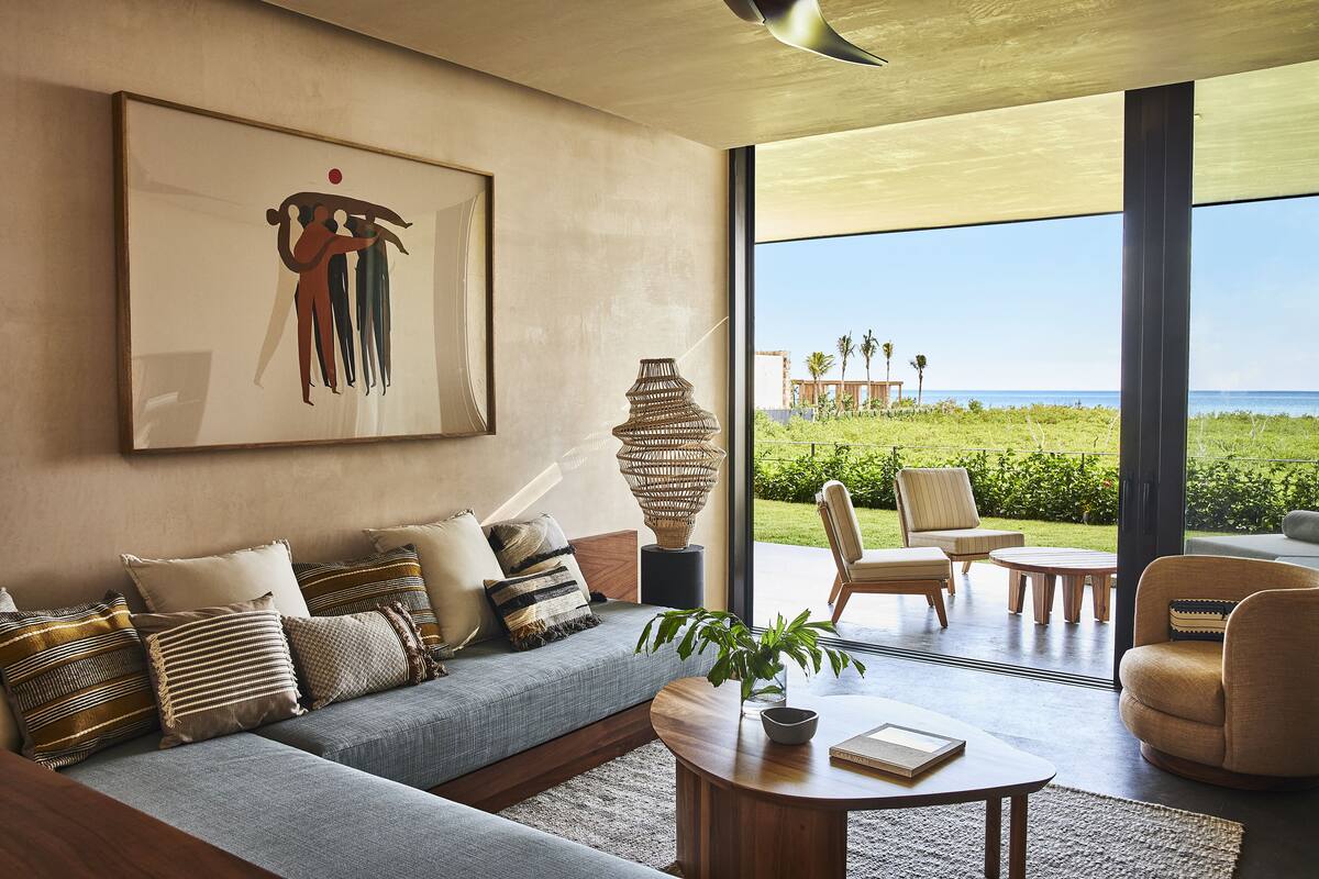 A modern living room with a large window, a sofa, a coffee table, and a decorative vase.