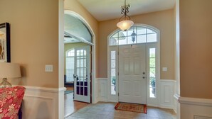 A hallway with a white door, a lamp, and a patterned rug. - Master's Rental (Evans)